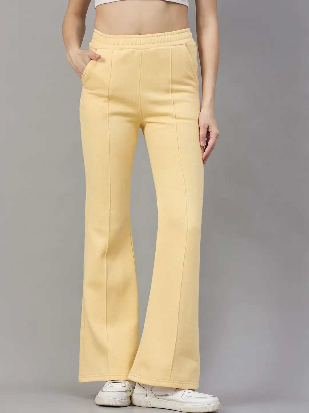A woman wears 98degreenorth’s Women’s Flared Sweatpants in Mango Melange, trendy winter wear for women.
