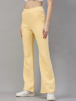 Woman in 98degreenorth Women’s Flared Sweatpants, Mango Melange, styled with a white crop top and sneakers.