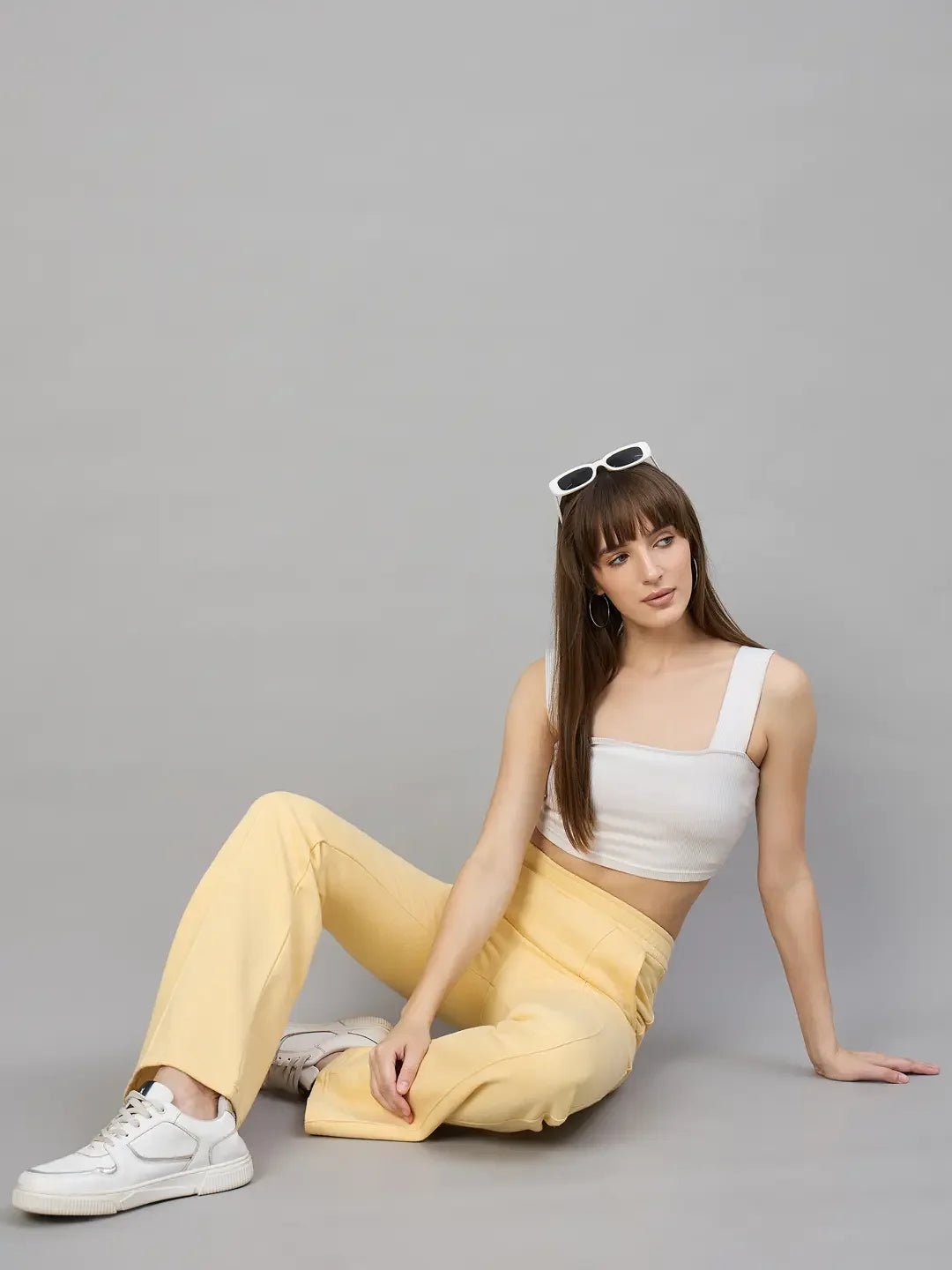 Woman in 98degreenorth Women’s Flared Sweatpants in Mango Melange—trendy winter wear for women, sits stylishly.