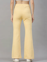Woman in 98degreenorth’s Mango Melange flared sweatpants—a trendy winter look—stands out against a gray backdrop.