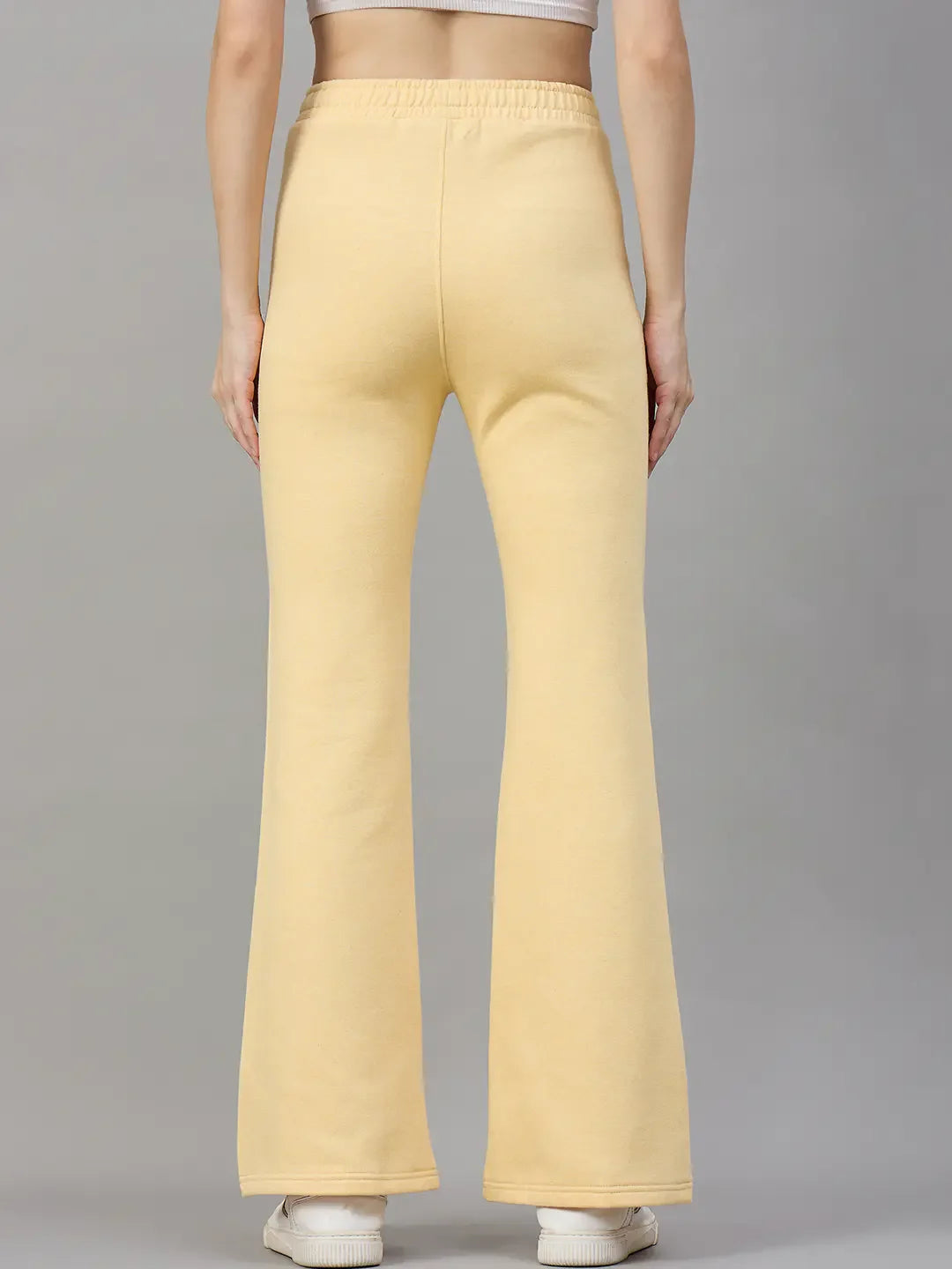 Woman in 98degreenorth’s Mango Melange flared sweatpants—a trendy winter look—stands out against a gray backdrop.