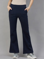 A woman models 98degreenorth Women’s Flared Sweatpants in Navy Melange, cozy winter lounge track pants.