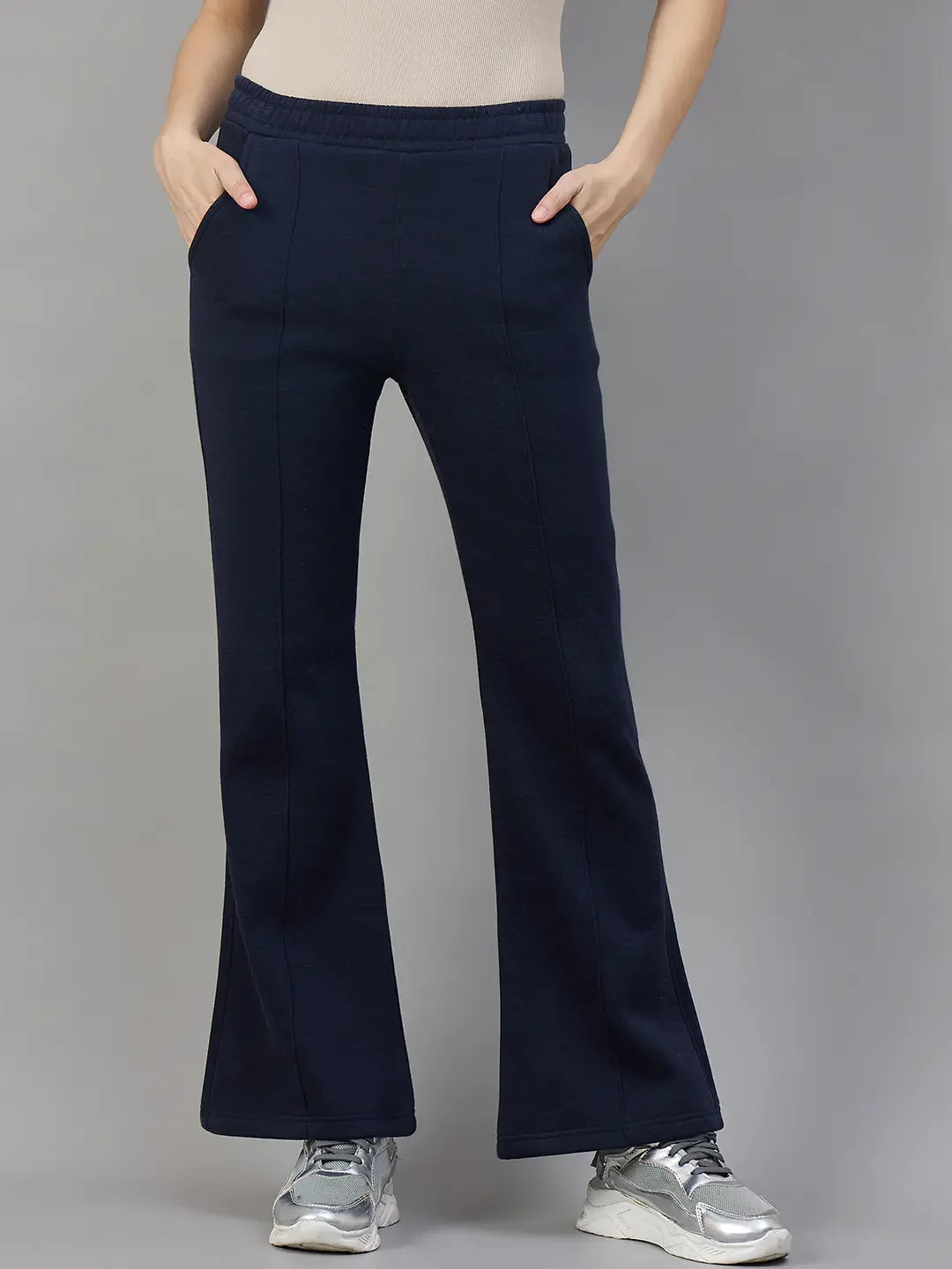 A woman models 98degreenorth Women’s Flared Sweatpants in Navy Melange, cozy winter lounge track pants.