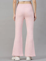 Model in 98degreenorth Women’s Flared Sweatpants in Pink Melange, shown from the back with white sneakers on gray background.