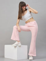 Woman wears 98degreenorth Women’s Flared Sweatpants in Pink Melange with a white crop top, sunglasses, and sneakers.