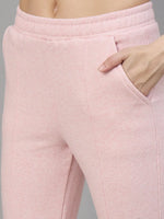 Close-up of a person wearing 98degreenorth Womens Flared Sweatpants in Pink Melange with hand in right pocket.