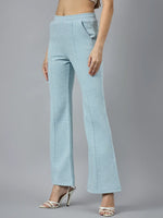 Model in 98degreenorth Women’s Flared Sweatpants in Sky Melange fleece, styled with white heels, on a gray backdrop.