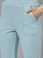 A woman wears 98degreenorth’s Sky Melange flared fleece sweatpants, hand in pocket, shown waist to mid-thigh.