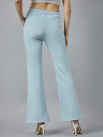 Model in 98degreenorth Women’s Flared Sweatpants in Sky Melange, shown from the back with white heels.