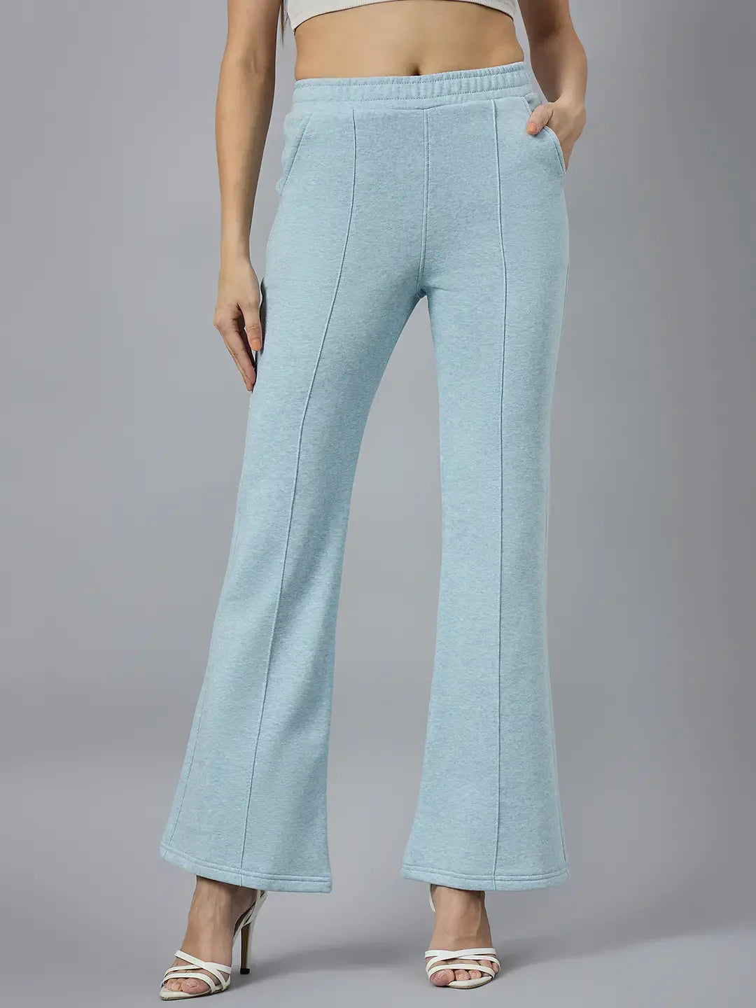Model wears 98degreenorth Women’s Flared Sweatpants in Sky Melange with side pockets, against a gray background.