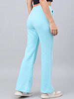 Model in 98degreenorth Women’s Flared Sweatpants in Turquoise Blue—cozy, stylish winter streetwear with white sneakers.