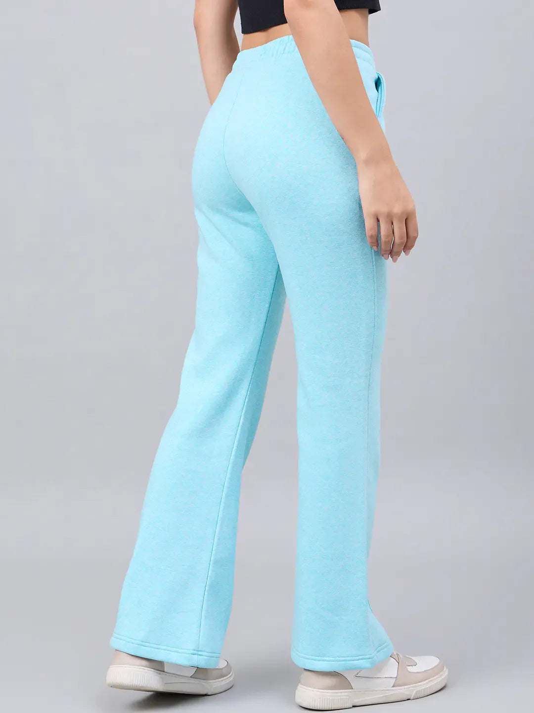 Model in 98degreenorth Women’s Flared Sweatpants in Turquoise Blue—cozy, stylish winter streetwear with white sneakers.