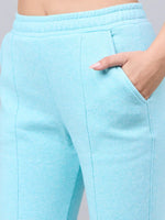 Close-up of a woman in 98degreenorth Women’s Flared Sweatpants in Turquoise Blue—ultra-soft and stylish winter streetwear.