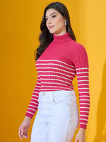Woman in a 98degreenorth fuchsia ribbed knit turtleneck sweater and white pants stands against a yellow background.