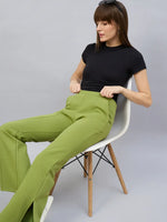 A woman adjusts her waistband in 98degreenorth Women’s Green Flared Bootcut Sweatpants with side slit.