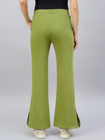 Person in 98degreenorth Women’s Green Flared Bootcut Sweatpants with side slits, black top, and white sneakers, back view.