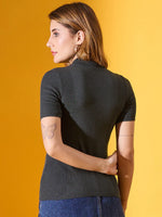 Woman with light brown hair wears 98degreenorth’s green ribbed slim fit turtle neck sweater, side view, yellow background.