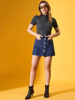 Woman wears 98degreenorth's green ribbed turtle neck sweater, denim mini skirt, and black boots on a yellow background.