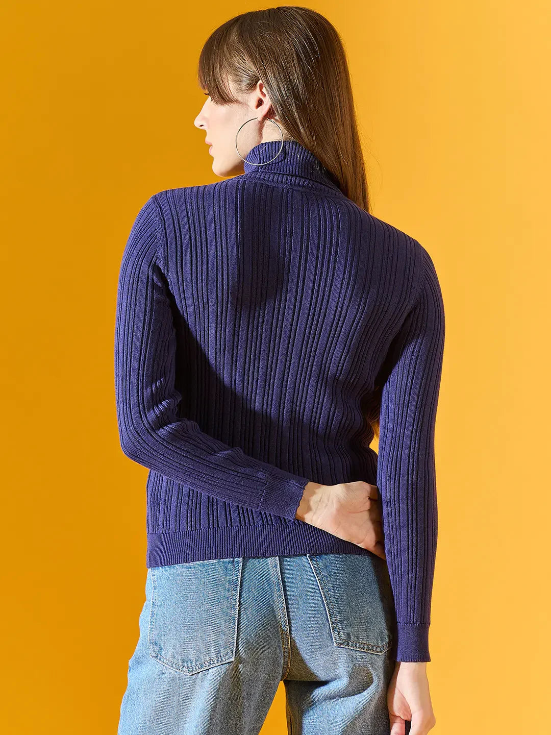Woman wears 98degreenorth Ink Blue Ribbed Turtleneck Stretchable Sweater, facing away against a yellow background.