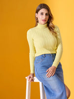 Woman in 98degreenorth Lemon Ribbed Turtleneck Sweater and blue skirt sits on a white stool, yellow background.