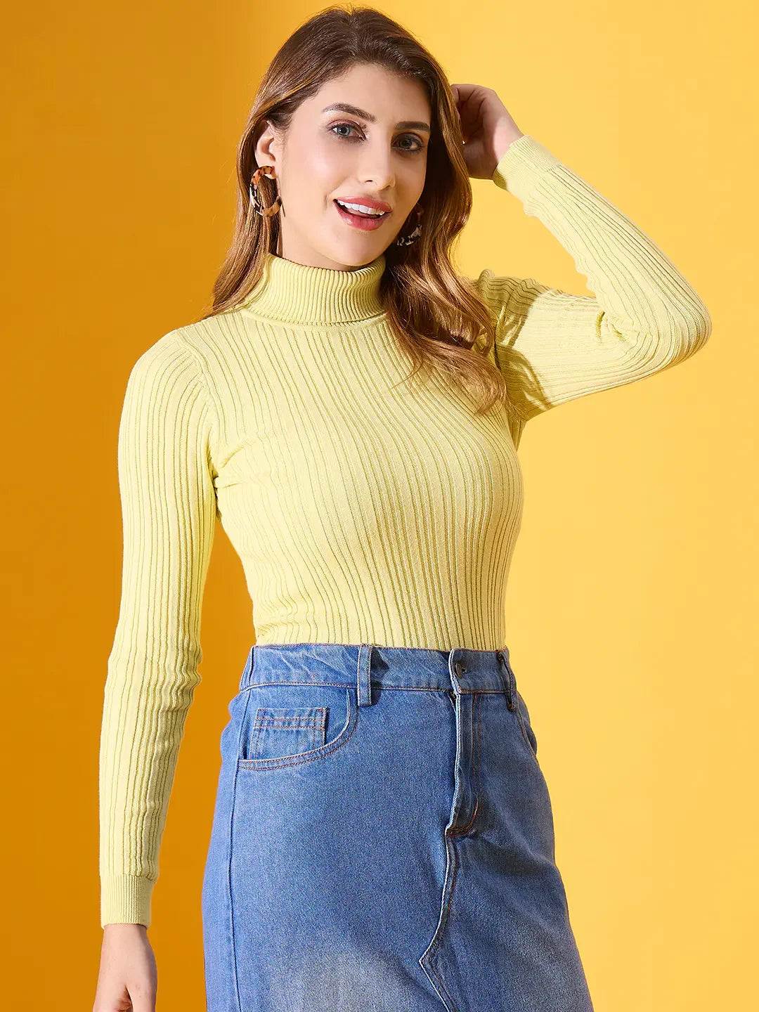 Woman in 98degreenorth lemon ribbed turtleneck sweater, blue denim skirt, smiling against a yellow background.