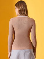 A woman in a 98degreenorth Light Camel Ribbed Collared Sweater and gray skirt, facing away on a yellow background.