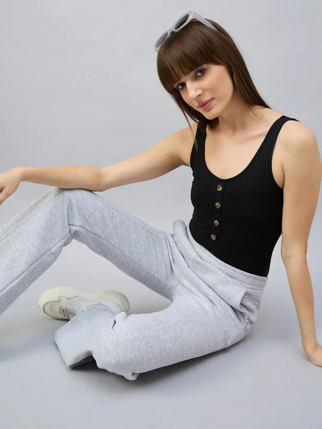 Woman in a black sleeveless top and 98degreenorth Women’s Light Grey Bootcut Sweatpants against a plain background.