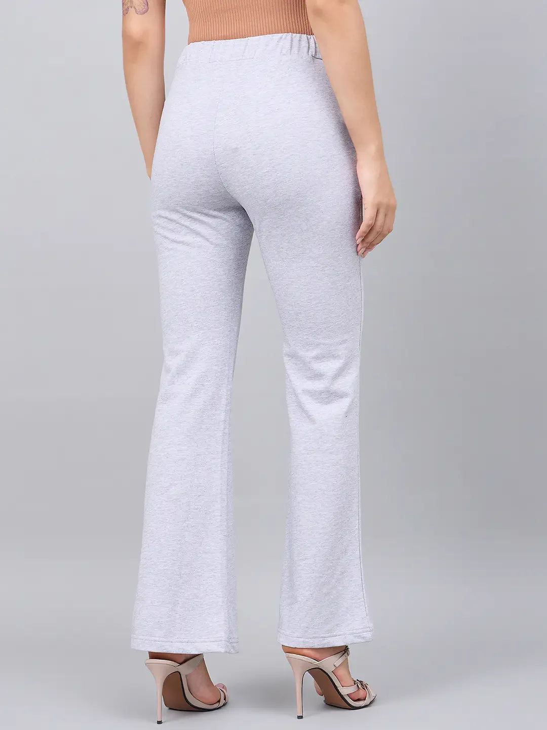 Woman wears 98degreenorth Light Grey Flared Bootcut Stretchable Trousers, seen from the back against a grey background.