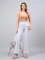 Woman in a tan tank top wears 98degreenorth Women’s Light Grey Flared Bootcut Cotton Stretchable Trousers.