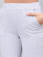 A woman models 98degreenorth’s light grey flared bootcut cotton stretch trousers, pictured waist down, hand in pocket.