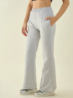 Woman in 98degreenorth Light Grey Flared Fit Bootcut Cotton Stretchable Trousers, black crop top, and silver sneakers.