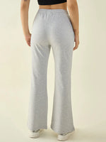 Person wears 98degreenorth Women’s Light Grey Flared Fit Bootcut Pants with a black crop top and white sneakers, back facing.
