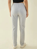 Woman in 98degreenorth Women’s Light Grey Cotton Stretchable Trousers, shown from the back with white sneakers.