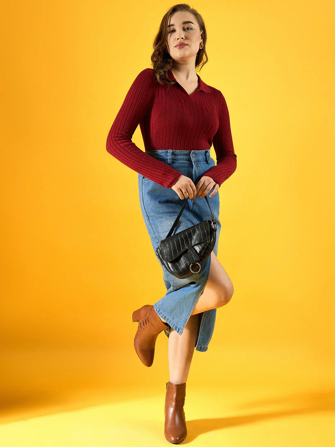 Woman wears 98degreenorth’s maroon ribbed collar neck slim fit sweater with denim skirt, black bag, and brown boots.