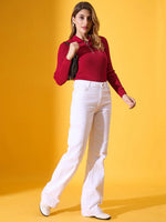 Woman wears 98degreenorth maroon ribbed collar zipper sweater with white pants, shoes, and a black purse against yellow.
