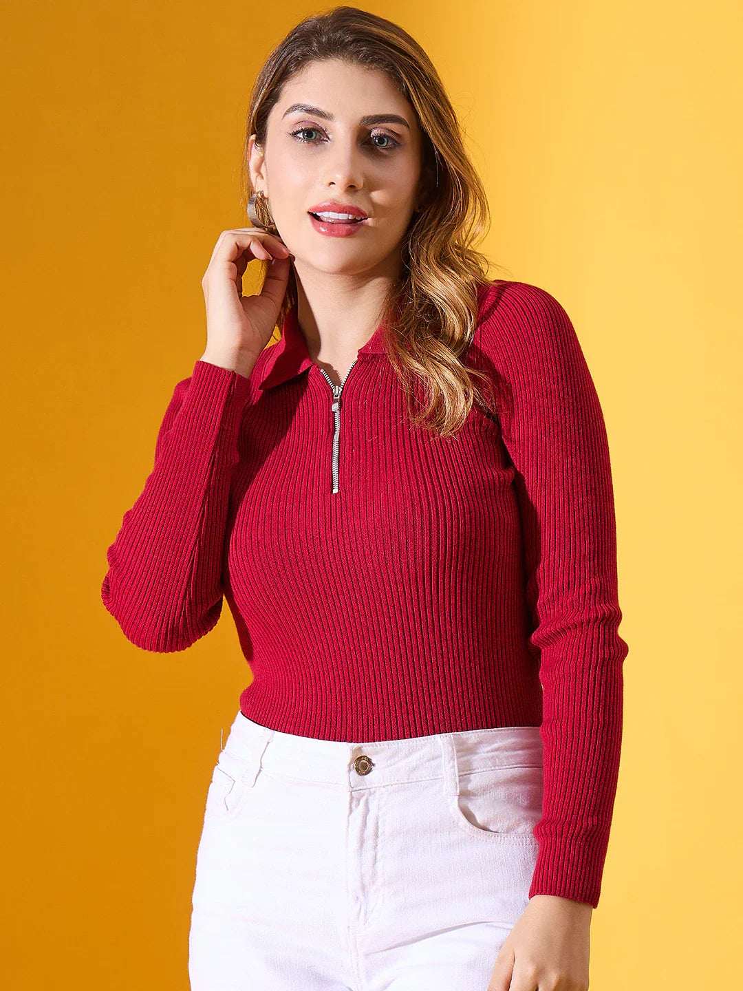 Woman wears 98degreenorth Women's Maroon Ribbed Collar Zipper Sweater with white pants against a yellow background.