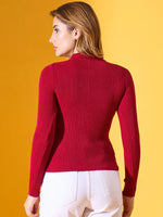 Woman in a 98degreenorth maroon ribbed collar zipper sweater and white pants stands against a yellow background.