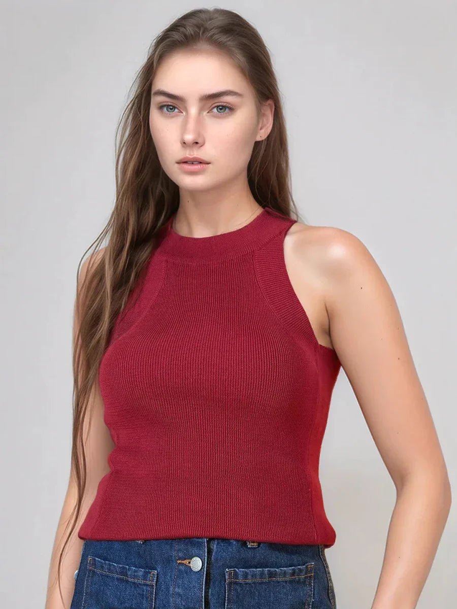 Woman with long brown hair wears 98degreenorth maroon ribbed halter neck slim fit sleeveless knit top and blue jeans.
