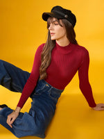 Woman in 98degreenorth maroon ribbed turtleneck slim fit sweater sits on floor, casual winter style.