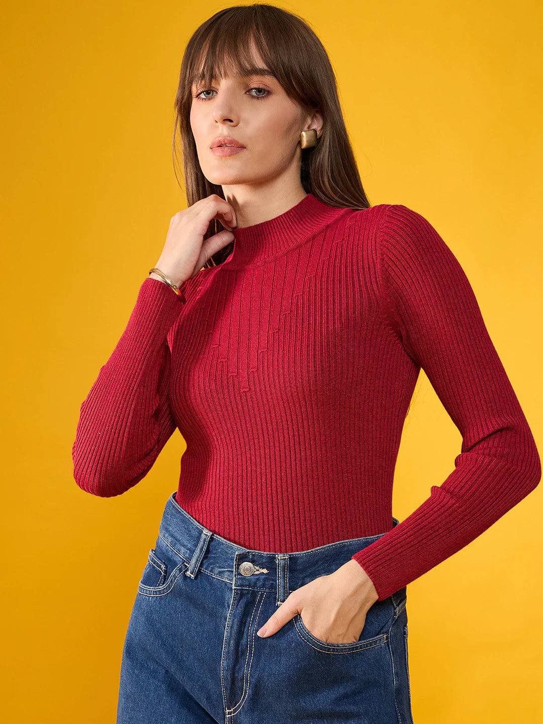 Model in a maroon ribbed slim fit sweater by 98degreenorth poses against yellow, highlighting winterwear for women.