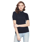 Woman in 98degreenorth navy blue ribbed turtle neck slim fit sweater and light blue jeans, against a white background.