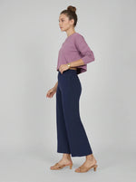 Woman in profile wears a mauve top and 98degreenorth Navy Blue Wide-Leg High-Rise Cotton Pants with tan sandals.
