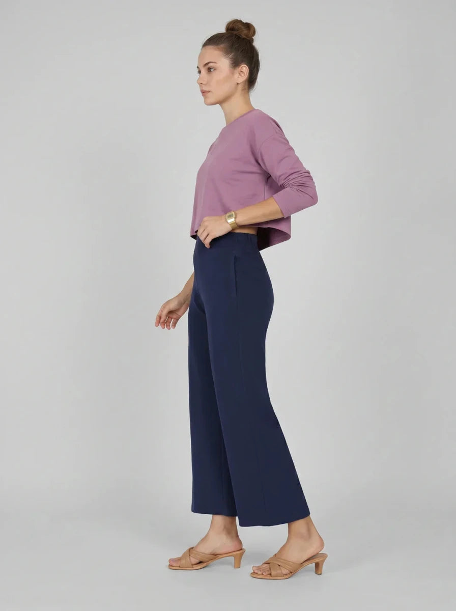 Woman in profile wears a mauve top and 98degreenorth Navy Blue Wide-Leg High-Rise Cotton Pants with tan sandals.