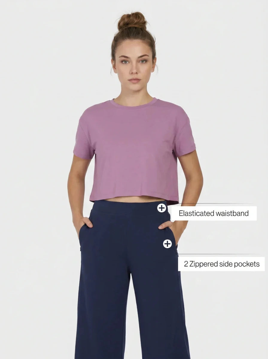 Woman in mauve cropped tee and 98degreenorth navy blue wide-leg, high-rise cotton pants.