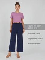 Woman in a pink cropped tee and 98degreenorth Navy Blue Wide-Leg High-Rise Cotton Pants, against a light background.