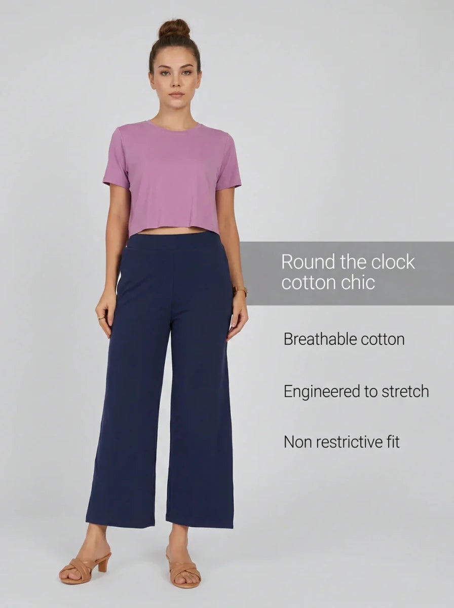 Woman in a pink cropped tee and 98degreenorth Navy Blue Wide-Leg High-Rise Cotton Pants, against a light background.