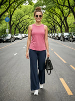 Smiling woman in sunglasses and pink top wears 98degreenorth Navy Blue Wide-Leg Cotton Pants, holding a black handbag.