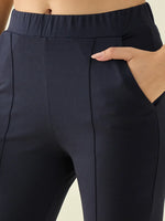 Model wears 98degreenorth Women’s Navy Flared Bootcut Cotton Stretchable Trousers, hand tucked in pocket.