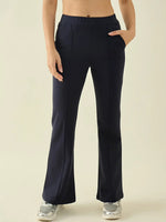 Woman wears 98degreenorth Navy Flared Bootcut Cotton Stretchable Trousers, hands in pockets, on plain background.