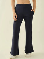 Model wears 98degreenorth Women’s Navy Flared Fit Bootcut Trousers with pockets and white sneakers, waist-down view.